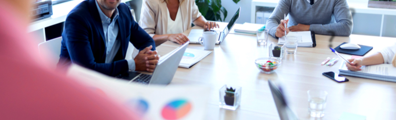 Équipe de direction réunie autour d’une table analysant des données et échangeant sur les objectifs afin d’évaluer l’efficacité de la stratégie d’affaires.